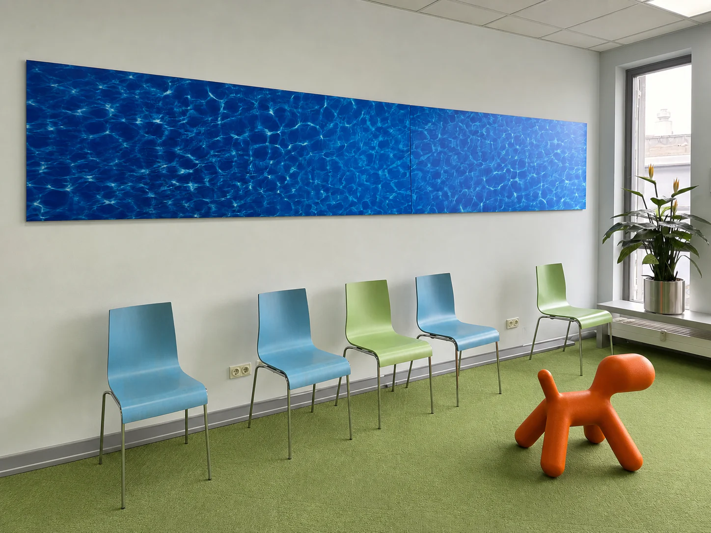 Ruhiger Wartebereich mit blau-grünen Stühlen und Wandbild